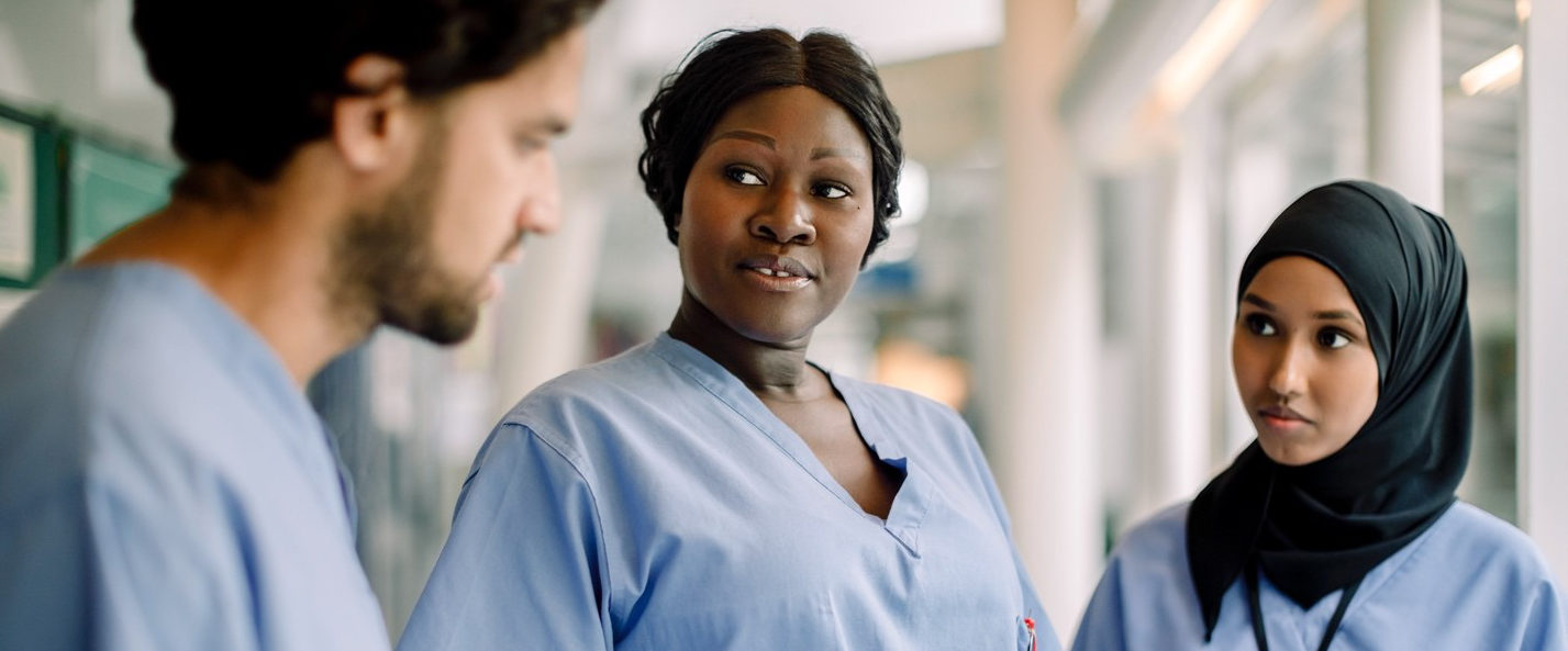 group of nurses in discussion while viewing a tablet device